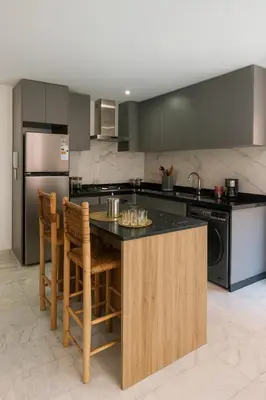 a kitchen with a island with chairs and a counter top at Duplex 3 chambres - Piscine & Gym à 5 min du Carre Eden - Marrakech Center in Oulad Akkou