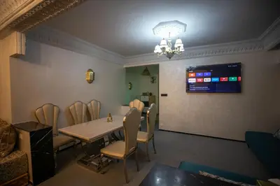 a dining room with a table and chairs and a television at Luxury Apartment in Fes New City Prime Location in Fès
