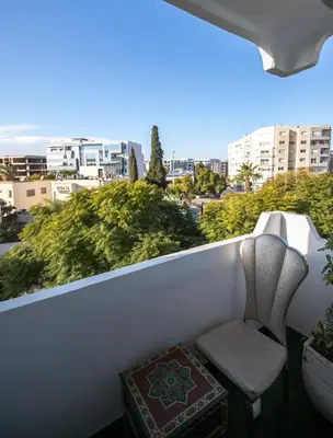 a chair sitting on a balcony with a view of a city at Luxury Apartment in Fes New City Prime Location in Fès