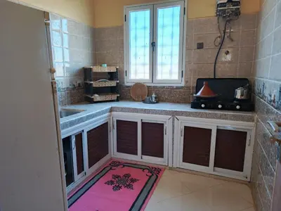 a kitchen with a counter and a sink and a window at Dar Bedda in Merzouga