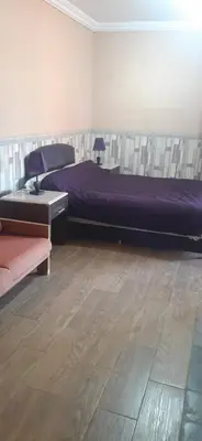 a bedroom with a purple bed and a wooden floor at Villa Sidi Abdellah Ghiat in Chrabli