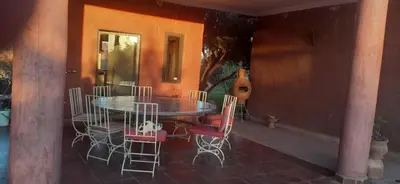 a patio with a table and chairs in a room at Villa Sidi Abdellah Ghiat in Chrabli