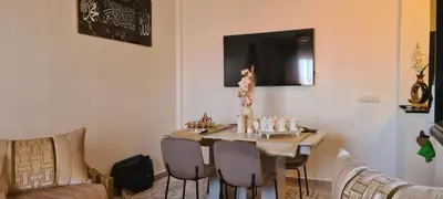 a living room with a table with chairs and a couch at Appartement Fes in Fès