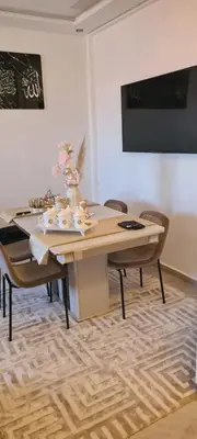 a dining room with a table and some chairs at Appartement Fes in Fès