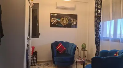a room with two blue chairs and a picture on the wall at Appartement Fes in Fès