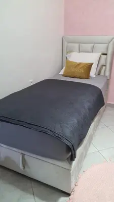 a bed with a gray frame and a yellow pillow at Appartement Fes in Fès