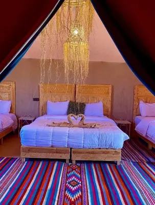 a bedroom with a bed in a tent at Merzouga tarwla camp in Merzouga