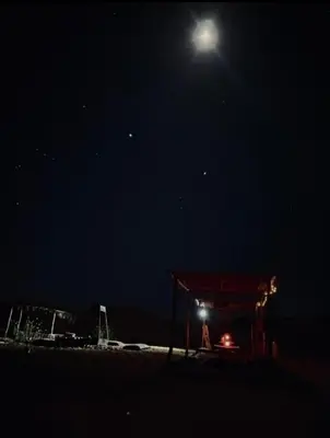 a night time picture of a moon over a beach at Merzouga tarwla camp in Merzouga