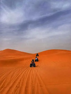 two people riding on quad bikes in the desert at Merzouga tarwla camp in Merzouga