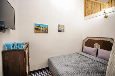 a small room with a bed and a tv at Riad haje skilf in Fès