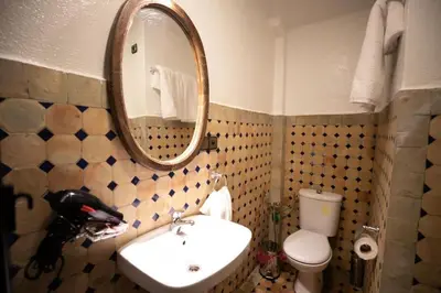 a bathroom with a sink and a mirror and a toilet at Riad haje skilf in Fès