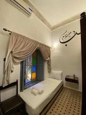a small room with a window and a bed at Riad haje skilf in Fès