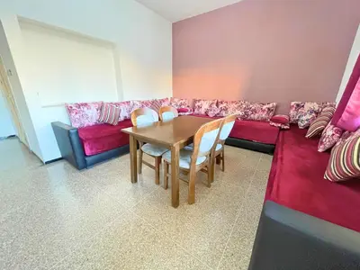 a living room with a table and a couch at 3Bed-Room City Centre Apartment - 3 min to Train Station in Fès