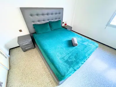 a bedroom with a bed with a blue bedspread and a pillow at 3Bed-Room City Centre Apartment - 3 min to Train Station in Fès