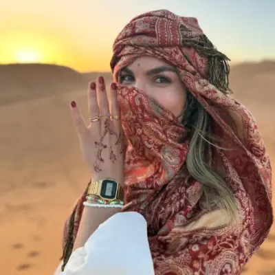 a woman in the desert wearing a scarf at Merzouga Explore Desert Camp in Merzouga