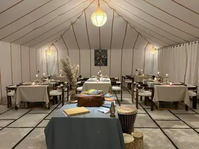a large tent with tables and chairs in it at Merzouga Explore Desert Camp in Merzouga