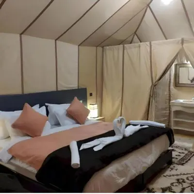 a bedroom with a bed with two towels on it at Merzouga Explore Desert Camp in Merzouga