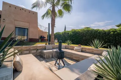 a backyard with a fire grill and a building at Villa Yasmine Sun, Relaxation & Private Pool in Douar bel Rhanodour