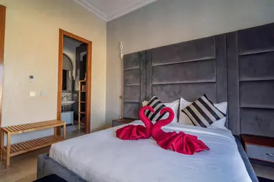a bed with a red ribbon on top of it at Villa Yasmine Sun, Relaxation & Private Pool in Douar bel Rhanodour