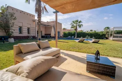 a living room with a couch and a table at Villa Yasmine Sun, Relaxation & Private Pool in Douar bel Rhanodour