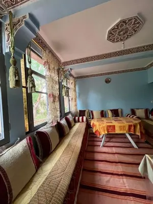 a living room with a table and chairs in it at Palmas Magramane Ogandou in Skoura