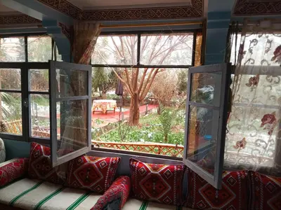 a couch with pillows sitting in front of two windows at Palmas Magramane Ogandou in Skoura