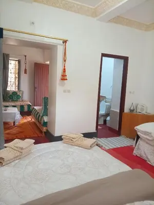 a bedroom with a large bed and a mirror at Palmas Magramane Ogandou in Skoura