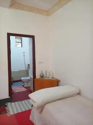 a bedroom with a bed and a bathroom with a toilet at Palmas Magramane Ogandou in Skoura