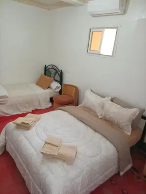 a bedroom with two beds and a window at Palmas Magramane Ogandou in Skoura