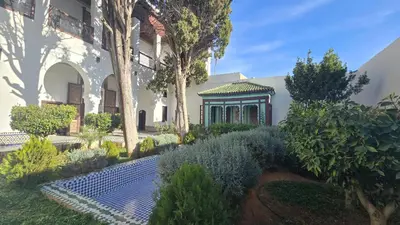 a garden in front of a house with trees and bushes at Meknès Cozy House by Yas in Meknès