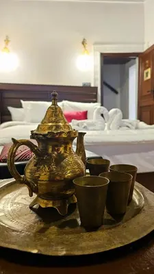 a gold tea pot and cups on a tray in a hotel room at Dar Karaouyine Panoramic in Fès
