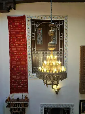 a chandelier hanging on a wall next to a mirror at Dar Karaouyine Panoramic in Fès