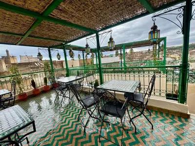 a patio with tables and chairs on a balcony at Dar Karaouyine Panoramic in Fès