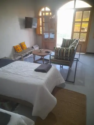 a bedroom with a bed and a table and chairs at Studio la petite Campagne Belgium Camp 50 km Near Marrakesh