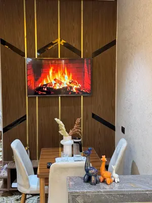 a fireplace in a living room with a table and a fireplace at Appartement confortable près du centre Meknes in Meknès