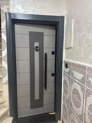 a large metal door in a room with a wall at Appartement confortable près du centre Meknes in Meknès