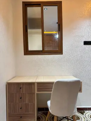 a desk with a mirror and a white chair at Appartement confortable près du centre Meknes in Meknès