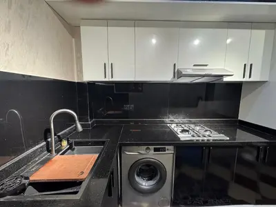 a kitchen with a sink and a washing machine at Appartement confortable près du centre Meknes in Meknès