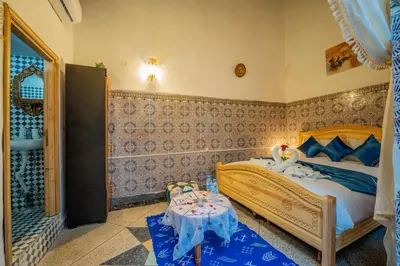 a bedroom with a bed and a table in it at Riad Chams Fes in Fès