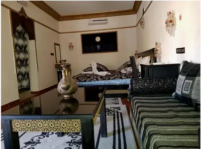 a living room with a bed and a couch at Maison d'hôtes Ambelar in Erfoud