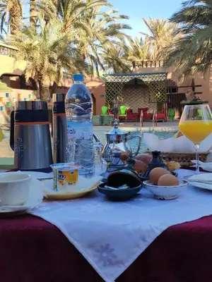 a table with food and a bottle of water on it at Maison d'hôtes Ambelar in Erfoud