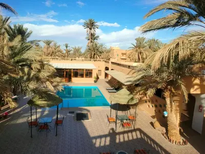 an aerial view of a resort with a pool and palm trees at Maison d'hôtes Ambelar in Erfoud