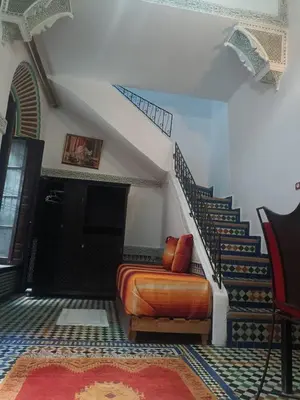 a bedroom with a bed and a stair case at Ryad Naila Fes in Fès
