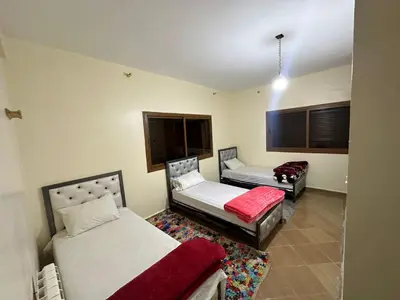 a room with two beds and a red blanket at auberge panorama ouiouane in Kasba des Aït Athmane