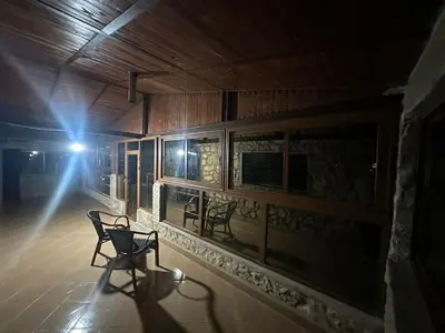 a bench sitting on the porch of a building at night at auberge panorama ouiouane in Kasba des Aït Athmane