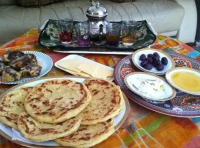 a table topped with plates of pancakes and other foods at auberge panorama ouiouane in Kasba des Aït Athmane