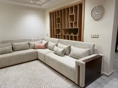 a living room with a couch and a clock on the wall at villa bijoux in Oulad Akkou