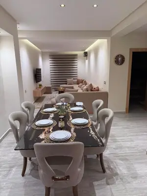 a dining table and chairs in a living room at villa bijoux in Oulad Akkou