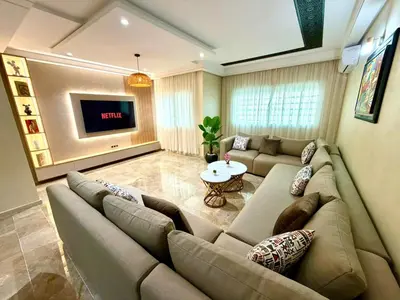 a living room with a couch and a tv at Appartement centre ville avec Wifi 200 Mo in Fès