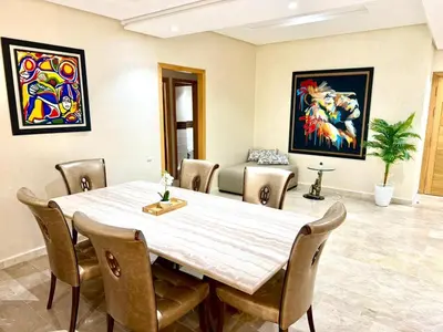 a dining room with a table and chairs at Appartement centre ville avec Wifi 200 Mo in Fès